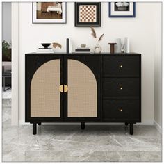 a black cabinet with two doors and some pictures on the wall next to it in a living room