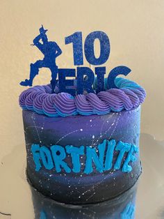 a purple and blue cake with the words fortnite written on it's side