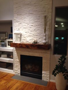 a living room with a white brick fireplace