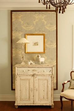 a room with a white cabinet and a chandelier