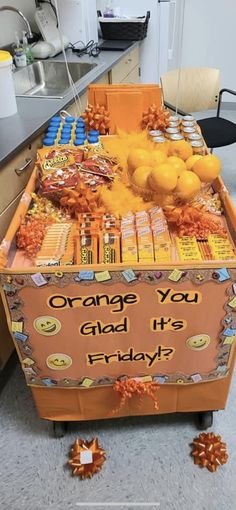 an orange box filled with candy sitting on top of a floor next to a counter