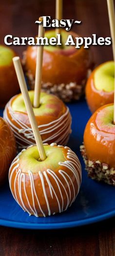 caramel apples on a blue plate with sticks sticking out of them and the words easy caramel apples above them