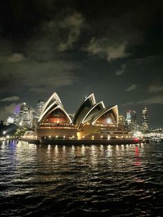 the sydney opera is lit up at night