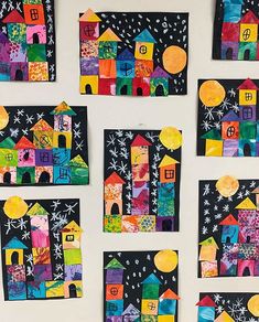 a white wall covered in lots of different colored paper cut outs with houses on them