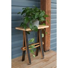 a potted plant sitting on top of a wooden table next to a blue wall