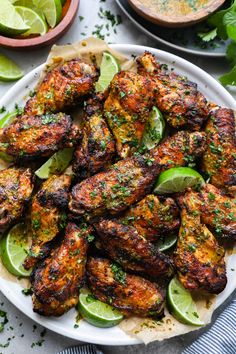 grilled chicken wings with limes and cilantro on a plate