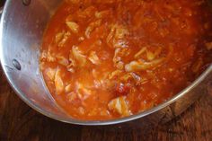 a metal bowl filled with pasta and sauce