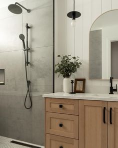 a bathroom with a sink, mirror and shower head in it's center area