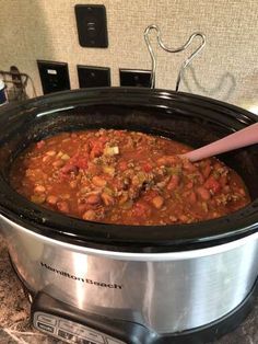 a slow cooker filled with chili and meat