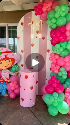 the balloon arch is decorated with pink, green and red balloons for a children's birthday party