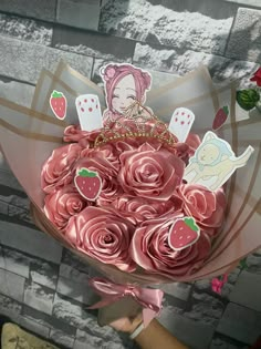 someone holding a bouquet of pink roses with stickers on the top and an angel above them