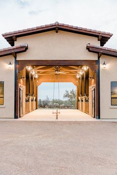 the front entrance to a building with an open door and two benches on each side