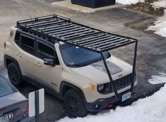 a white jeep with a black roof rack in the snow