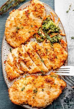 chicken with broccoli and carrots on a white plate next to a fork