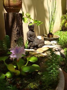 a buddha statue sitting in the middle of a garden