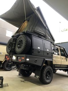 an off - road vehicle parked in a garage with its roof up and the door open