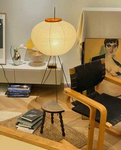 a living room filled with furniture and a painting on the wall next to a lamp