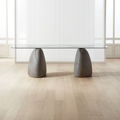 a glass table sitting on top of a hard wood floor next to a white wall