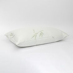 a white pillow with green bamboo print on it