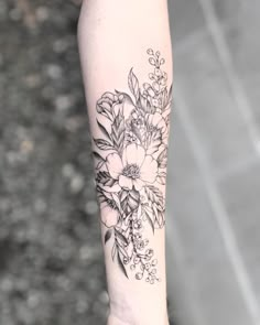 a black and white flower tattoo on the arm