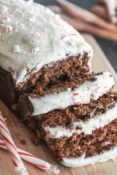 a close up of a piece of cake with white frosting and candy canes