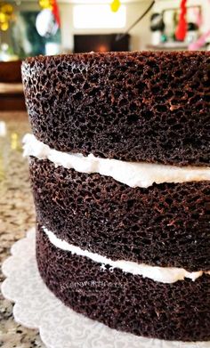 a three layer chocolate cake sitting on top of a white plate