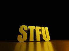 the word stfu is placed in front of a black background with light shining on it