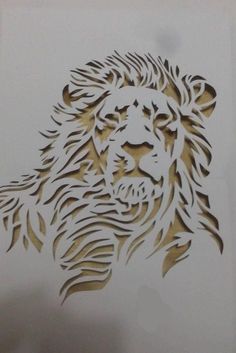 a drawing of a lion's head is shown in gold and silver foil on white paper