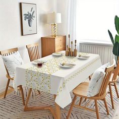 a dining room table is set with place settings and plates on it, along with two chairs