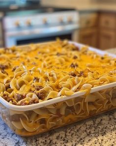 a casserole dish with cheese and ground beef in it on a kitchen counter