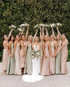 a group of women standing next to each other holding bouquets in front of them