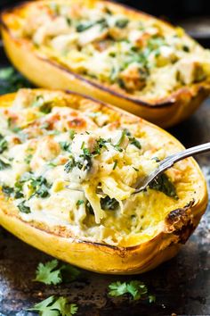 two stuffed acorns with cheese and spinach are on a plate, one has a spoon in it