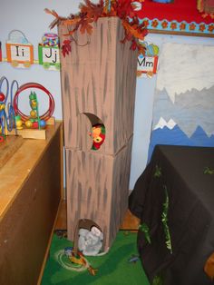 a child's play area with a cardboard tree house and stuffed animals in it