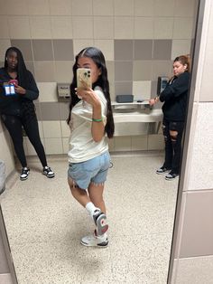 a woman taking a selfie in a bathroom mirror