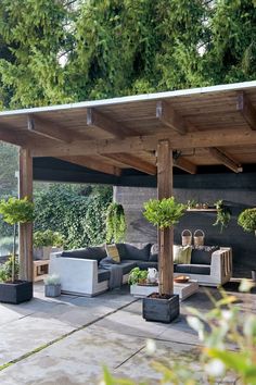 an outdoor living area with couches and potted plants