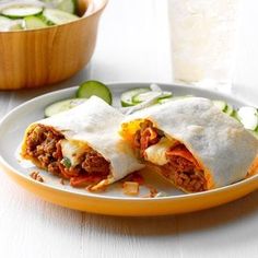 two burritos cut in half on a plate