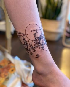 a person's arm with a tattoo on it that has an image of two people riding horses