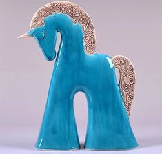 a blue ceramic horse statue sitting on top of a table