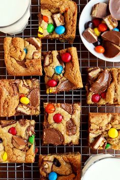 chocolate chip cookies, m & m bars and milk on a cooling rack