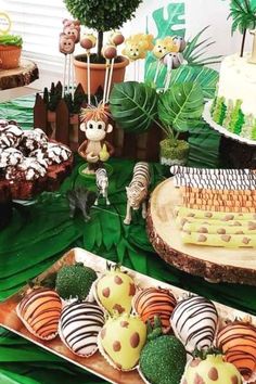 an assortment of desserts on display at a jungle birthday party