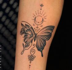 a black and white butterfly tattoo on the right arm, with a crescent moon in the background