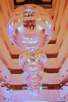 disco balls are hanging from the ceiling in a room with white walls and blue lights