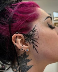 a woman with pink hair and tattoos on her face