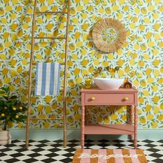 a bathroom with yellow and green wallpaper next to a white sink on a checkered floor