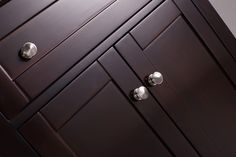 a close up of a brown cabinet with knobs on it's doors and drawers