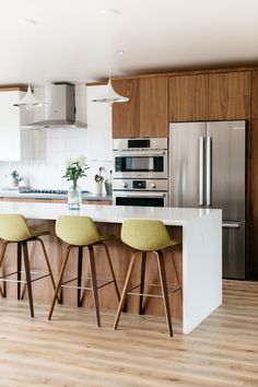 three stools are in front of the kitchen island