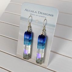 the earrings are made with glass and have blue, purple and white stripes on them