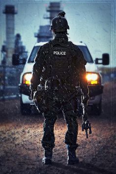 a police officer standing in front of a car on a road with traffic lights behind him