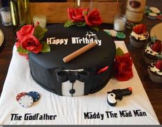 a black birthday cake with red roses on it and the words happy birthday, maddy the mad man