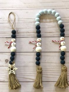 three snowmen are hanging on the wall with tassels attached to each bead